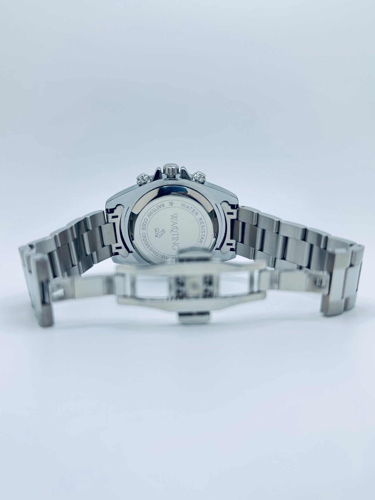 Silver watch with a detailed face on a light gray background