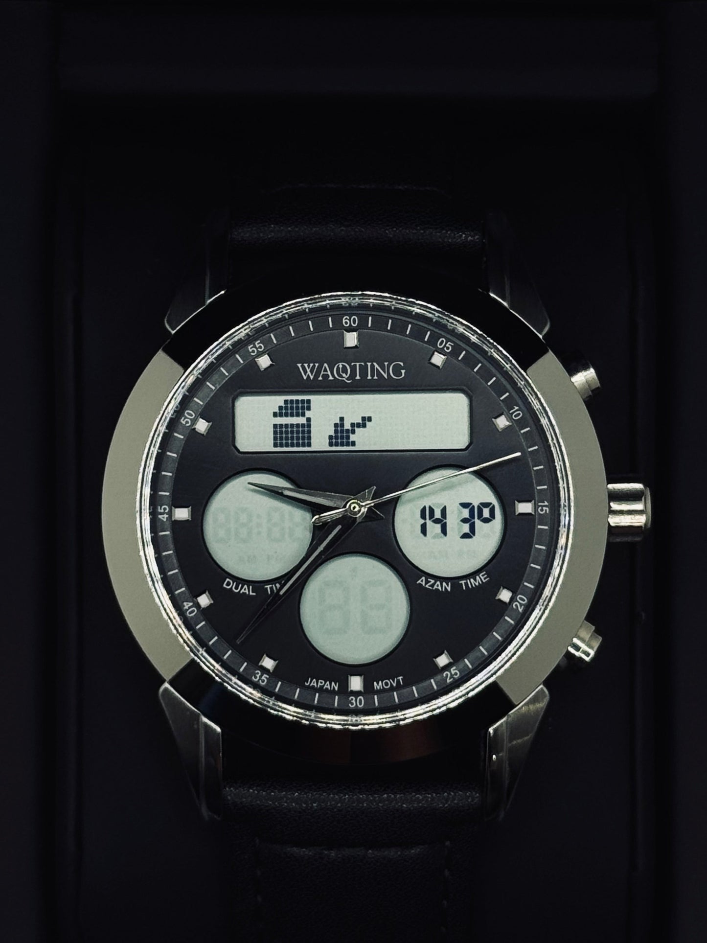 Black digital watch with multiple time zones and features on a dark background
