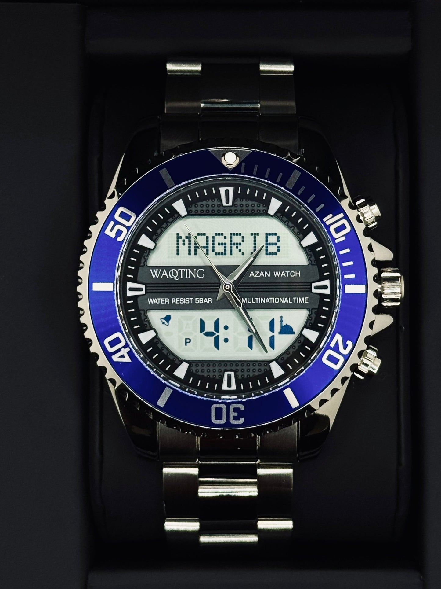 Digital watch with blue bezel and silver band on a black background