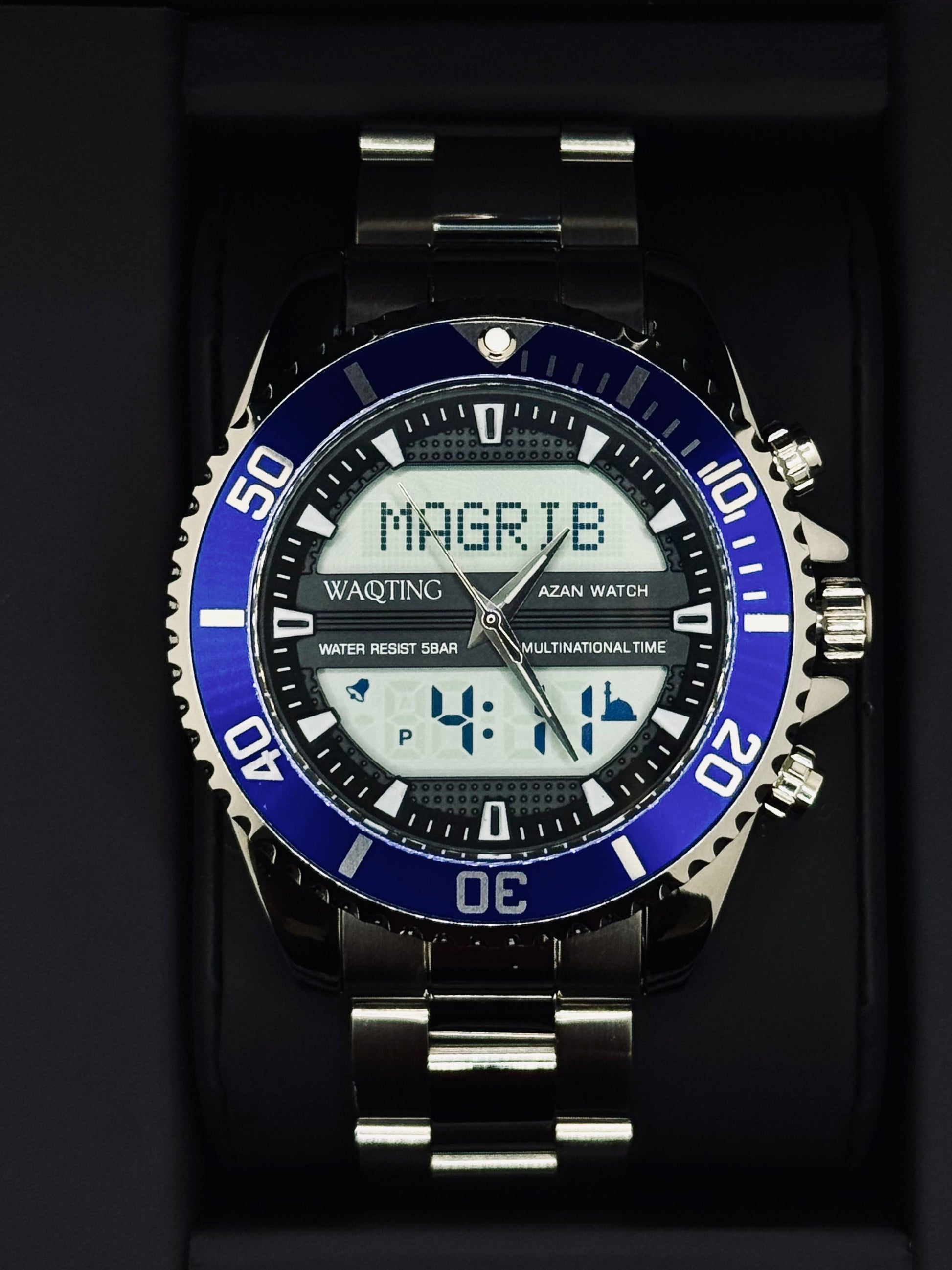 Digital watch with blue bezel and silver band on a black background