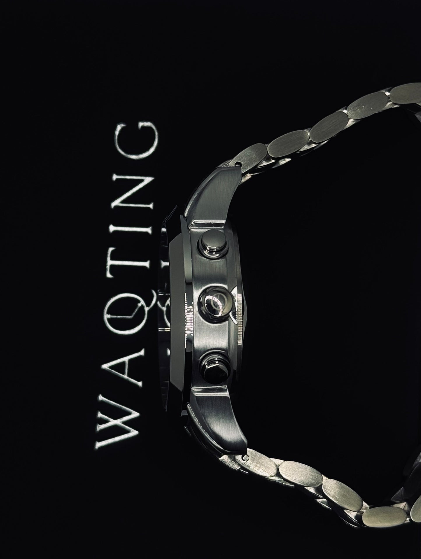 Silver watch with 'WAQTING' text on a black background