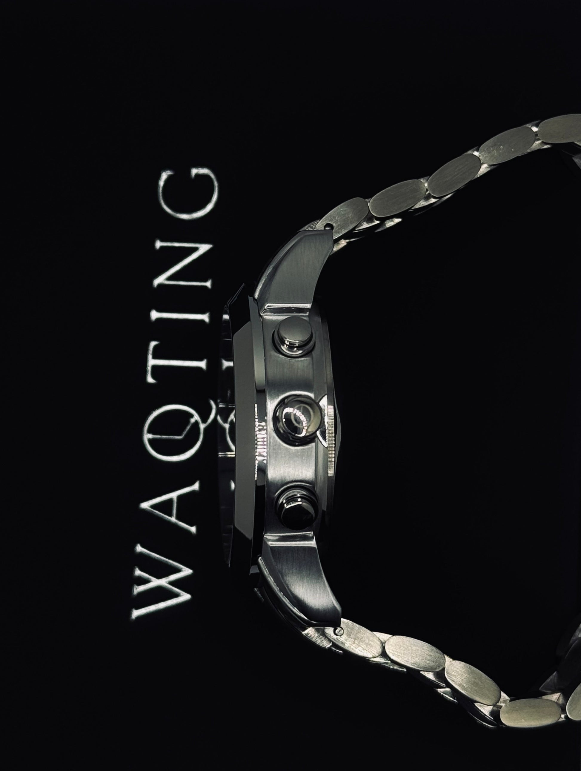 Silver watch with 'WAQTING' text on a black background
