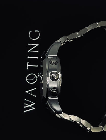 Silver watch with 'WAQTING' text on a black background